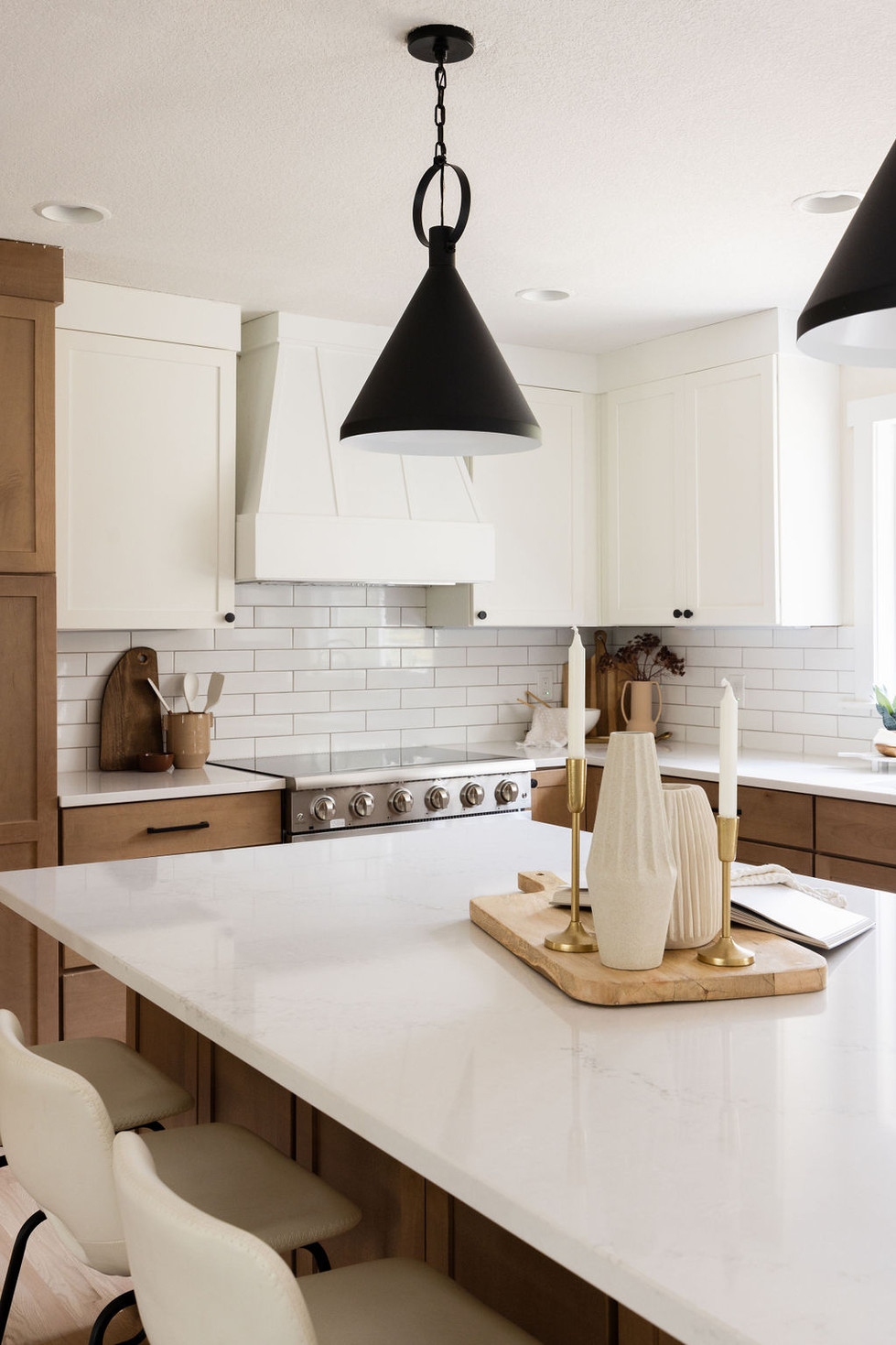 Revamped kitchen with white island, wood cabinets, subway tile.