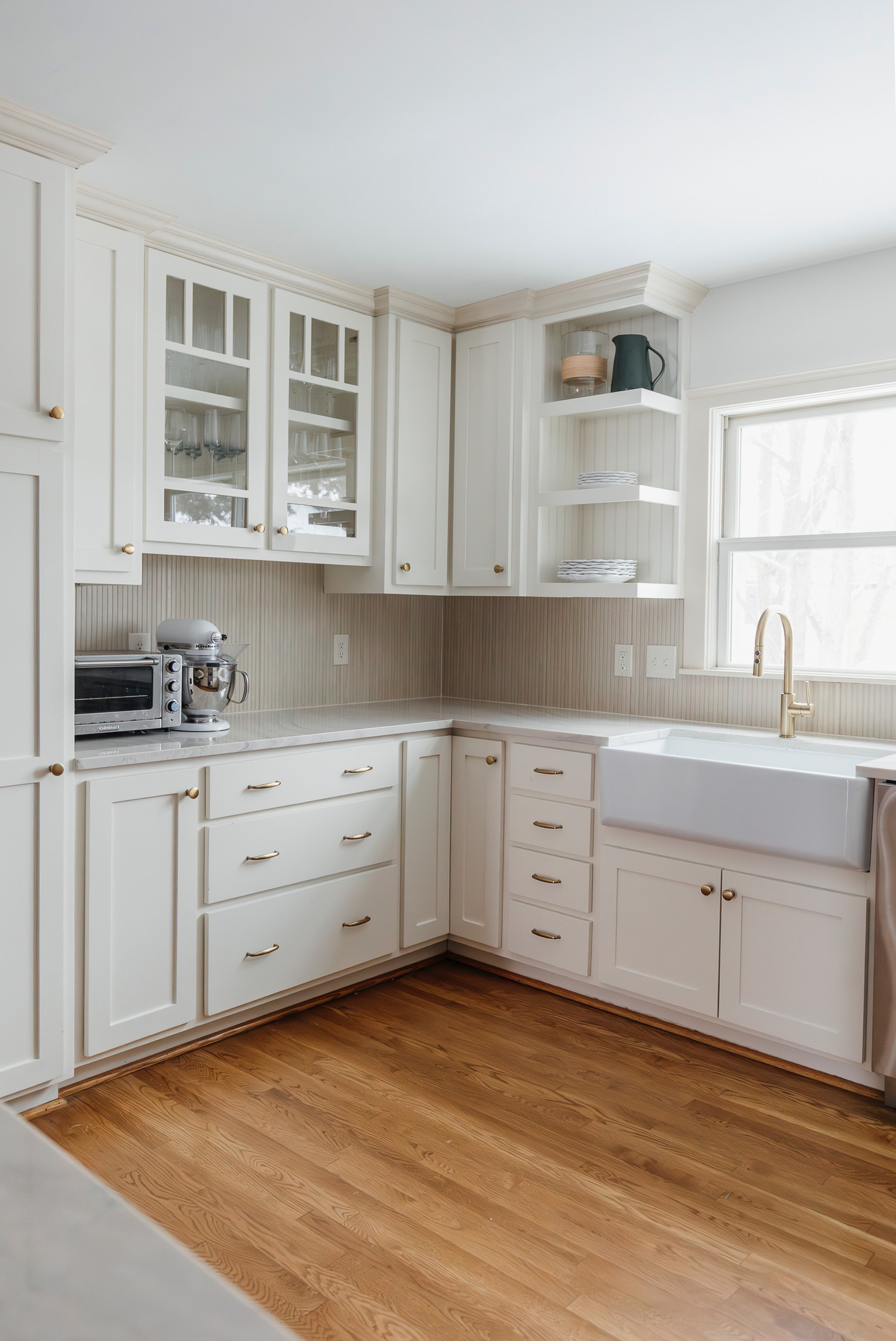 Modern white kitchen with farm sink and wood floor