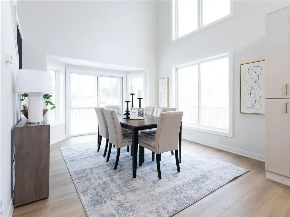 Open concept dining room with vaulted ceilings and back patio door leading to the deck