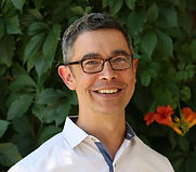 Head shot of man in front of plants