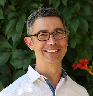 Head shot of man in front of plants