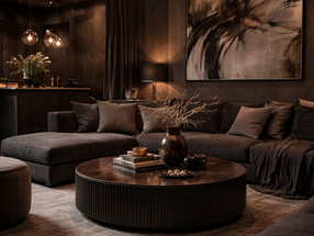 Dark luxury living space, with round coffee table and corner sofa.