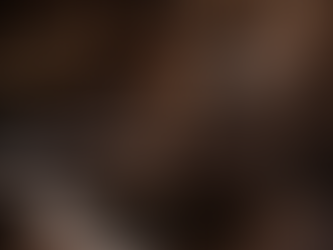 Dark luxury living space, with round coffee table and corner sofa.