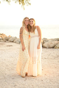 Key West photography session against a pink sunset and rocky shore.