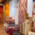 Brightly colored rugs and pillows on display in Boorju Rugs of Santa Fe, NM