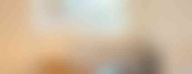 Glass decantur, serving tray, and decorative metal bowl on dining room sideboard with Southwest-style antler chandelier in background