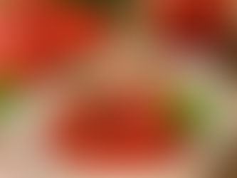 Pieczony sos pomidorowy z czosnkiem i ziołami oraz listkiem bazylii podany w białej misce.