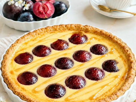 Flan ze śliwkami wypełniony kremem waniliowym i karmelem, podany w białej, okrągłej formie.