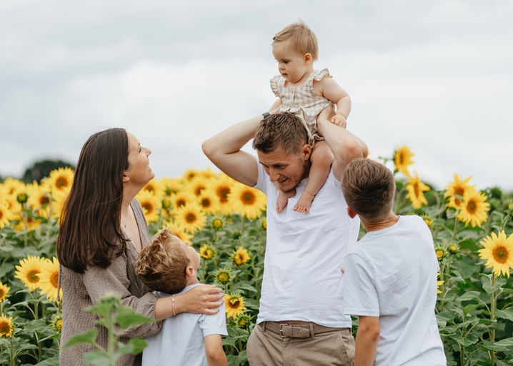 Family with young children in a sunflower field at Writtle