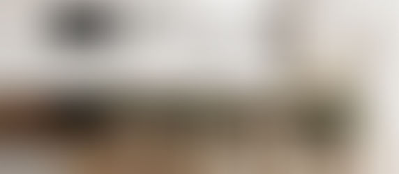 Modern dining room with a wooden table, green chairs, and pendant lights. A fireplace is on the right. "YOUR LOGO" text on the wall.