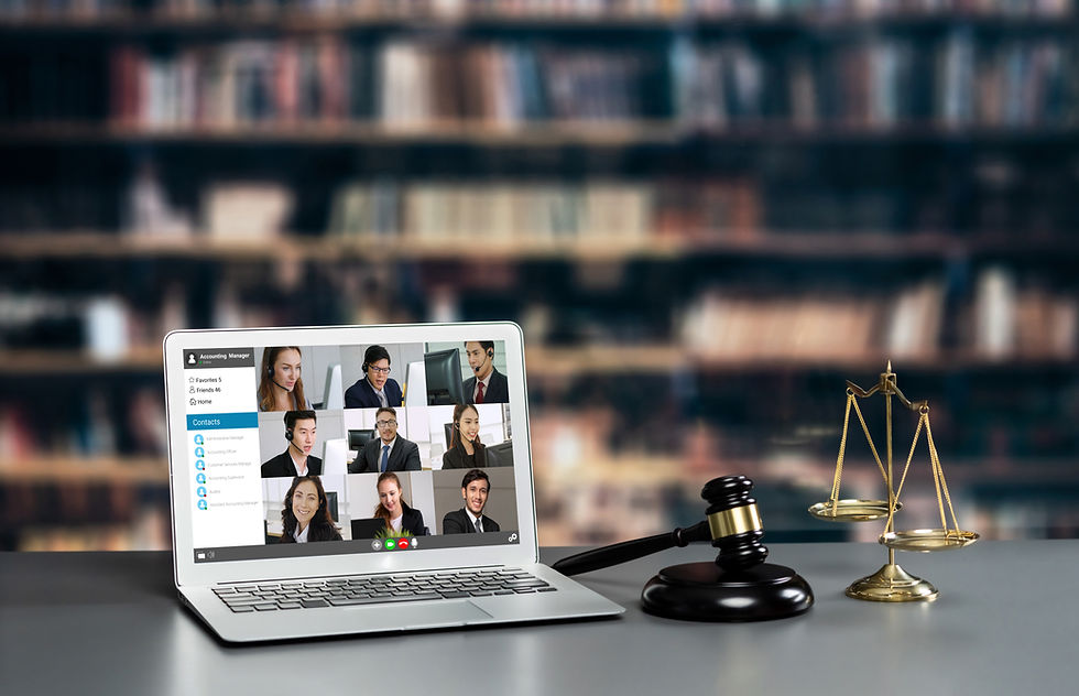 Laptop showing a video conference with nine people in a library setting. A judge's gavel and scales of justice are on the desk.