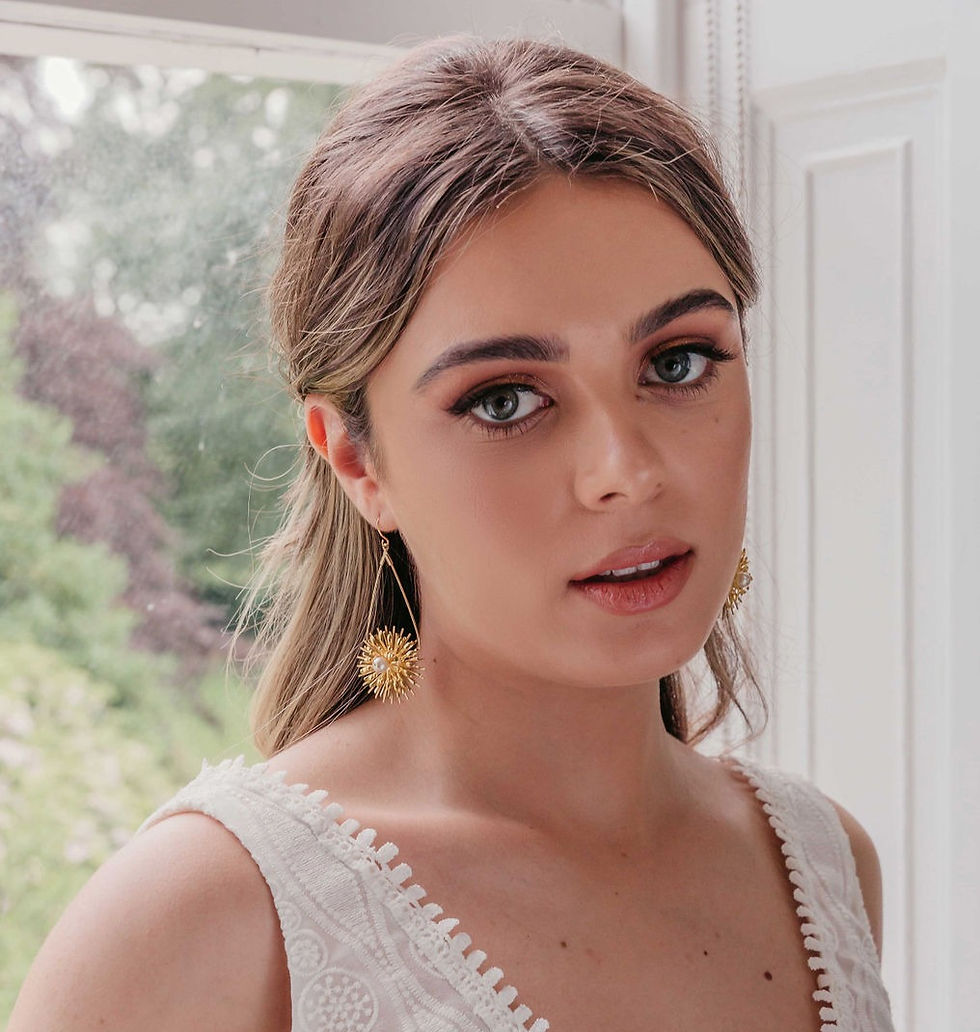 Bridal earrings with gold starbursts and a pearl centre, perfect for a star-loving bride on her celestial wedding day.