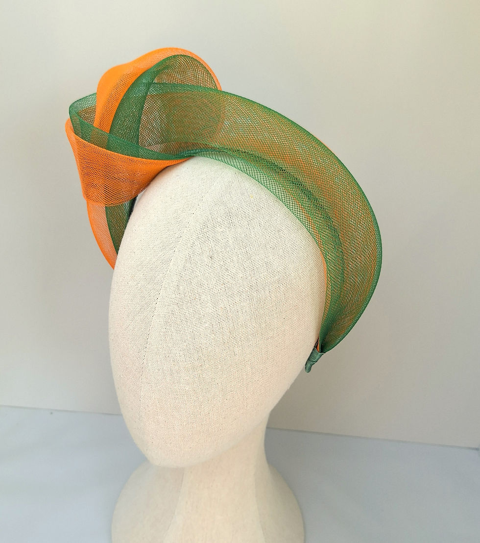Striking green and tangerine floral headpiece on a mannequin, perfect for making a statement at Royal Ascot and race day even