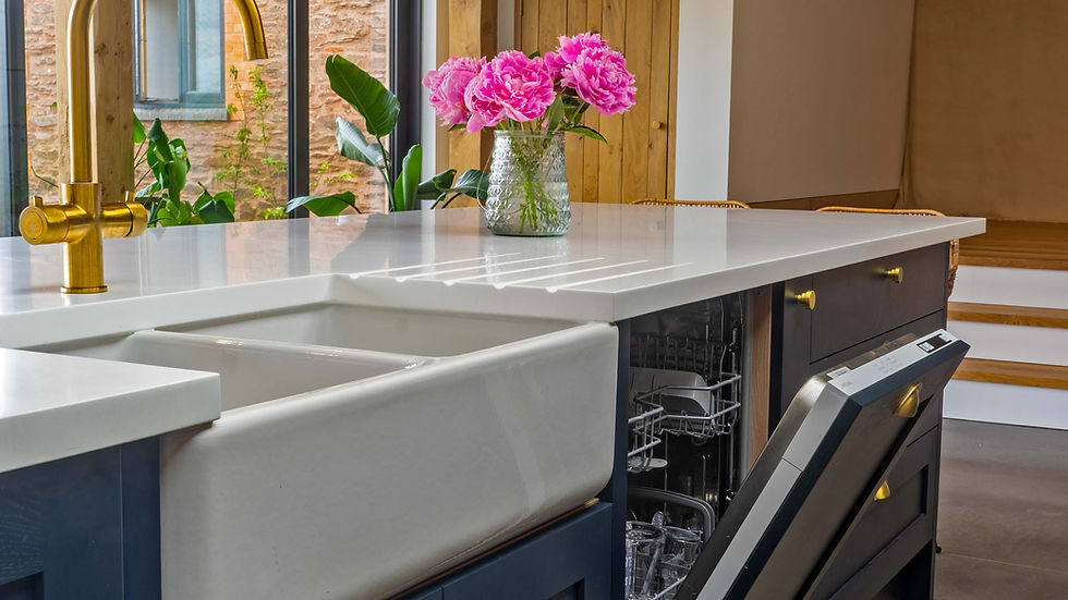 Close-up view of a farmhouse sink with brass faucet in a traditional kitchen