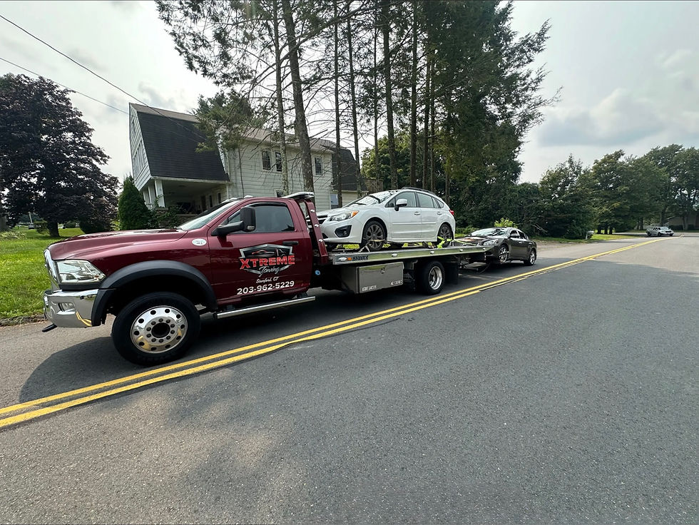 Xtreme Towing flatbed truck providing emergency roadside recovery at the I-95 and Route 8 interchange in Bridgeport, CT.