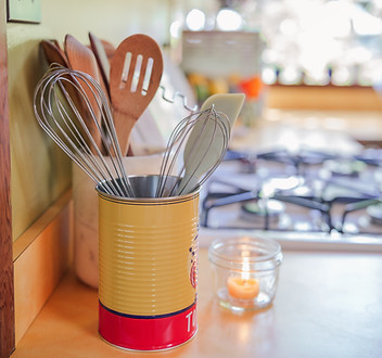 Cozy kitchen countertop with cooking utensils and candlelight, showing the warm home-style dining space at Hamakua Sanctuary.