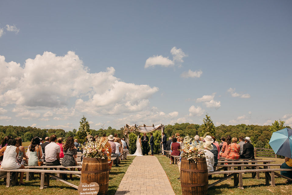 Outdoor wedding ceremony with wooden arbor and rolling hills views at Cedar Hills Farm wedding venue in Soddy Daisy near Chattanooga, TN