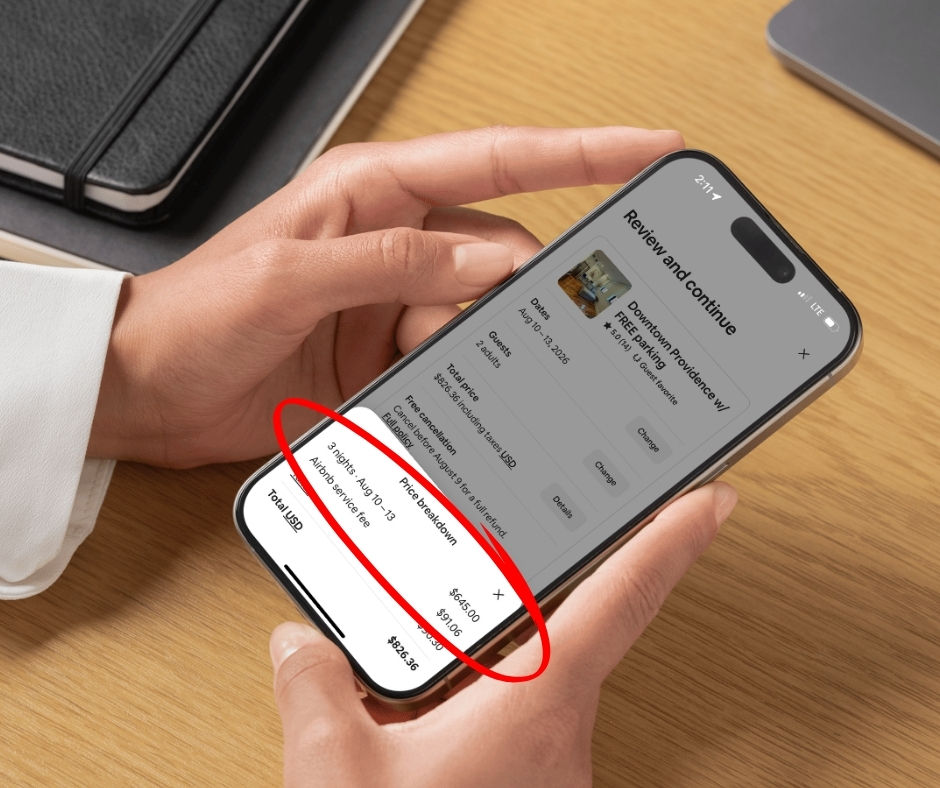 A hand holding a cell phone with airbnb booking fees depicted on the screen.