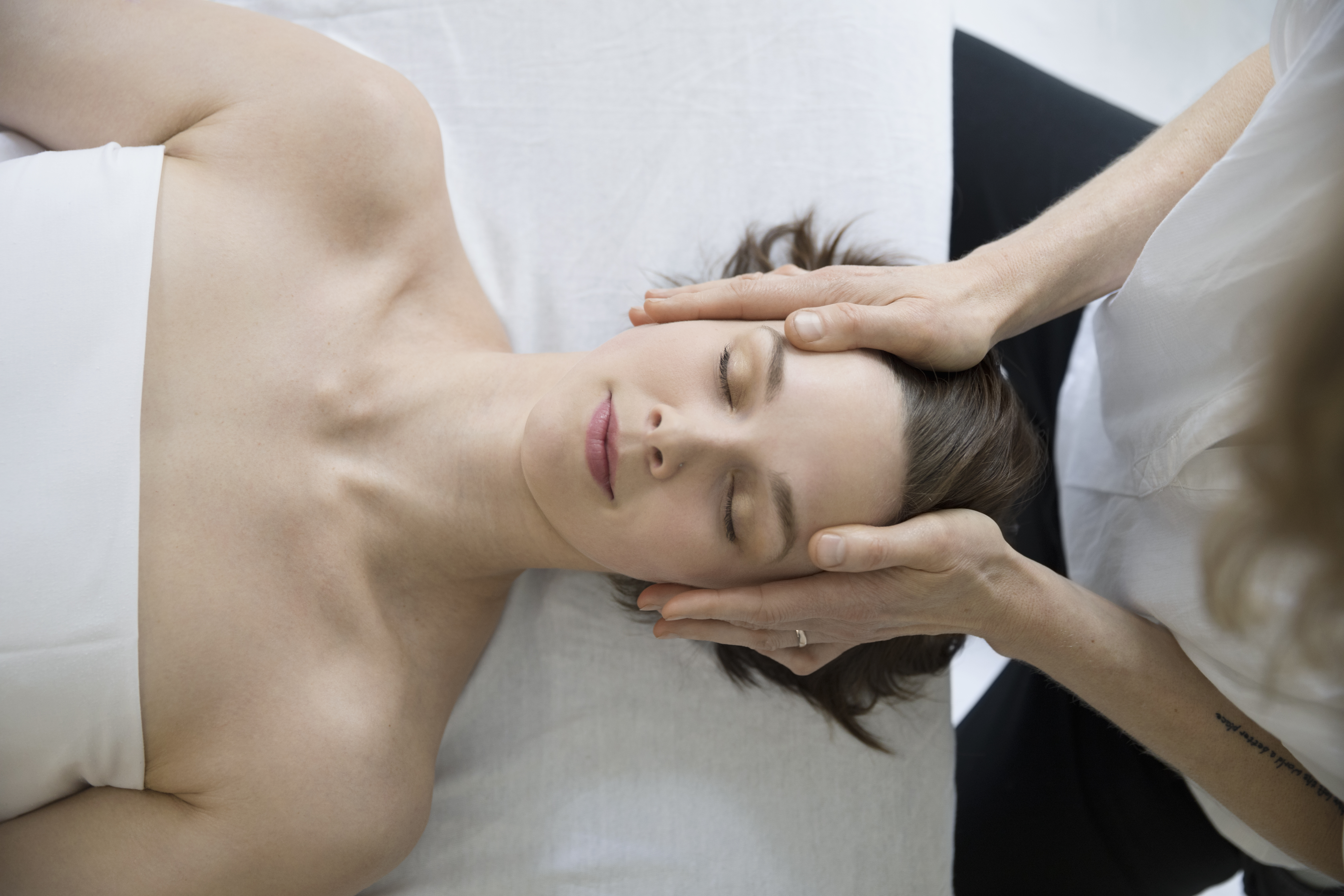 hands holding head during fertility care massage