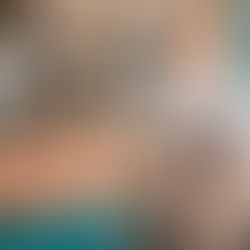 Close-up of hands clasped, person on blue couch in Encompass Christian Counseling session. Therapist holds notes, blurred shelves in background, warm tones.