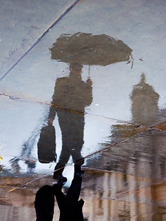 Thrive Future, Management Consultant, reflection in pavement, man with umbrella, wet city street