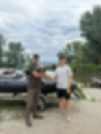 A NextGen Production tulajdonosa Kis Balázs és az Allroundmarin képviselője kezet fognak egy tréleren álló Allroundmarin gumicsónak előtt a kikötőben. A kamerával a kézben végzett forgatás az Allroundmarin webáruház videós tartalomgyártási projektjének része.
