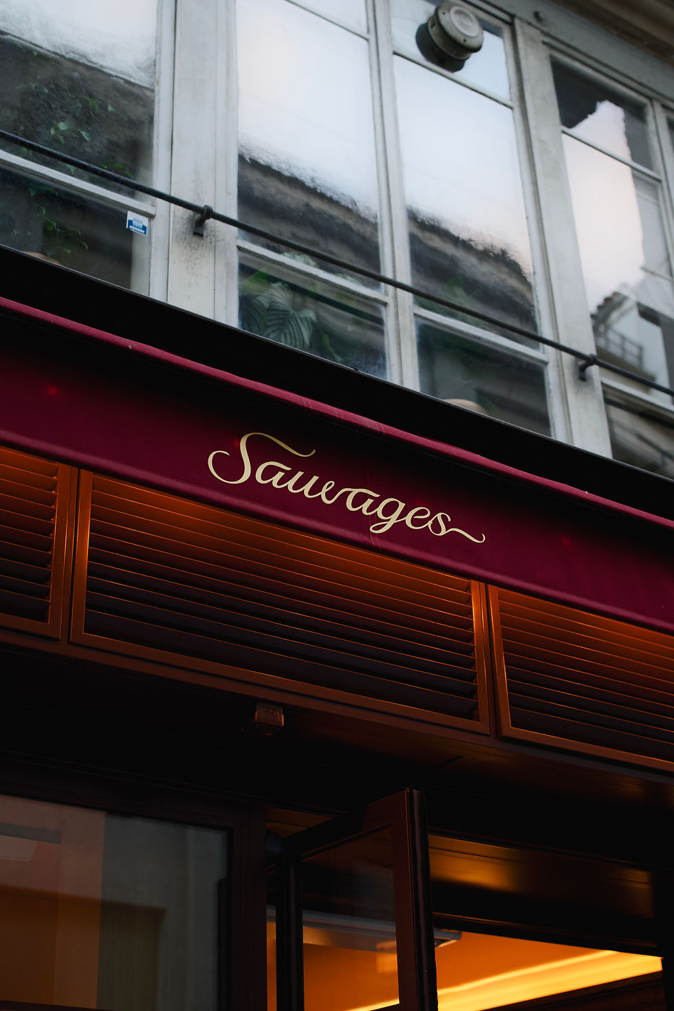 Enseigne Sauvages - Bistrot parisien & bar sur store rouge.
