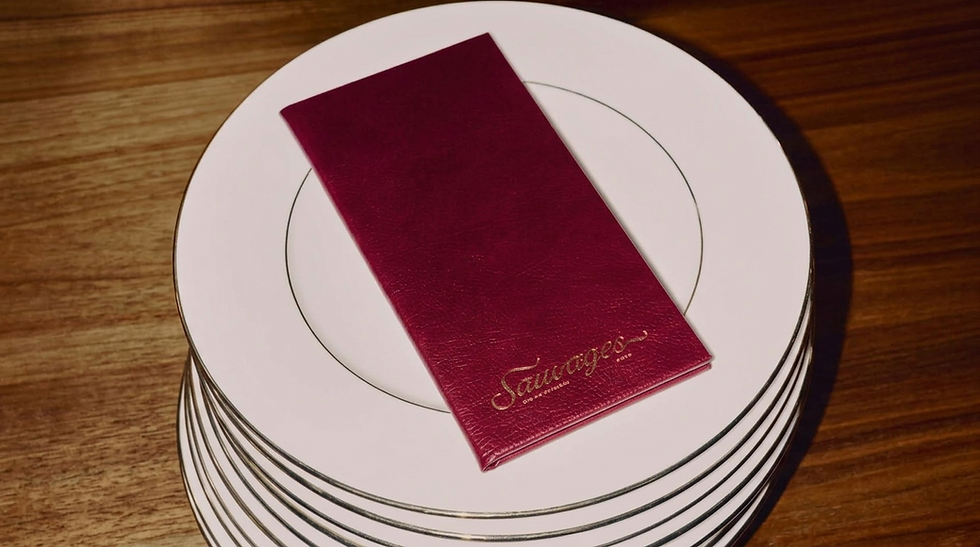 Menu bordeaux Sauvages sur une pile d'assiettes blanches