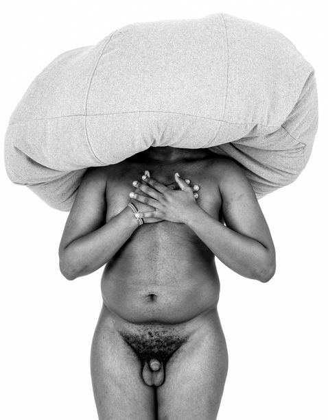 "front view of a naked man with a beanbag on his head disguising his identity."