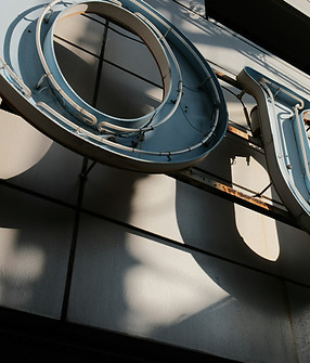 Close-up of a weathered neon sign on a b