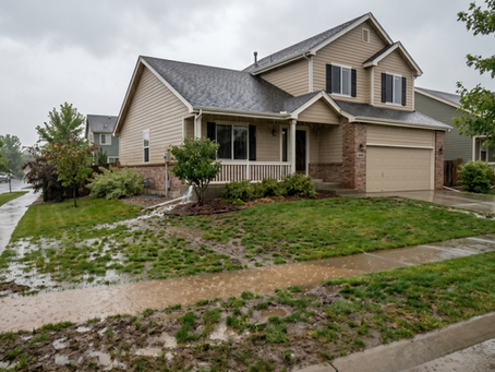A home during a rain storm has poor drainage that overwhelms the landscaping.