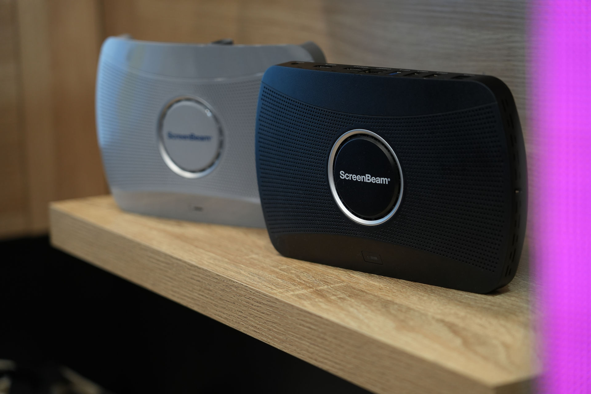 Light gray and black ScreenBeam devices on a shelf
