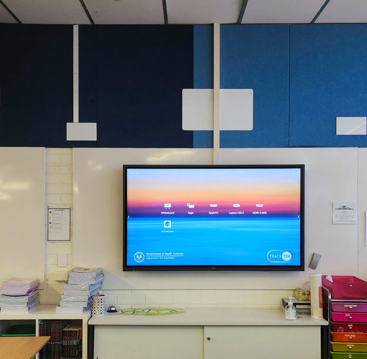 Interactive flat panel display mounted in a school learning space with blue accent walls