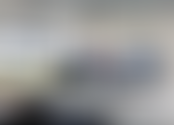 A classroom with an LCD display mounted to the wall, connected to a camera and hybrid learning system