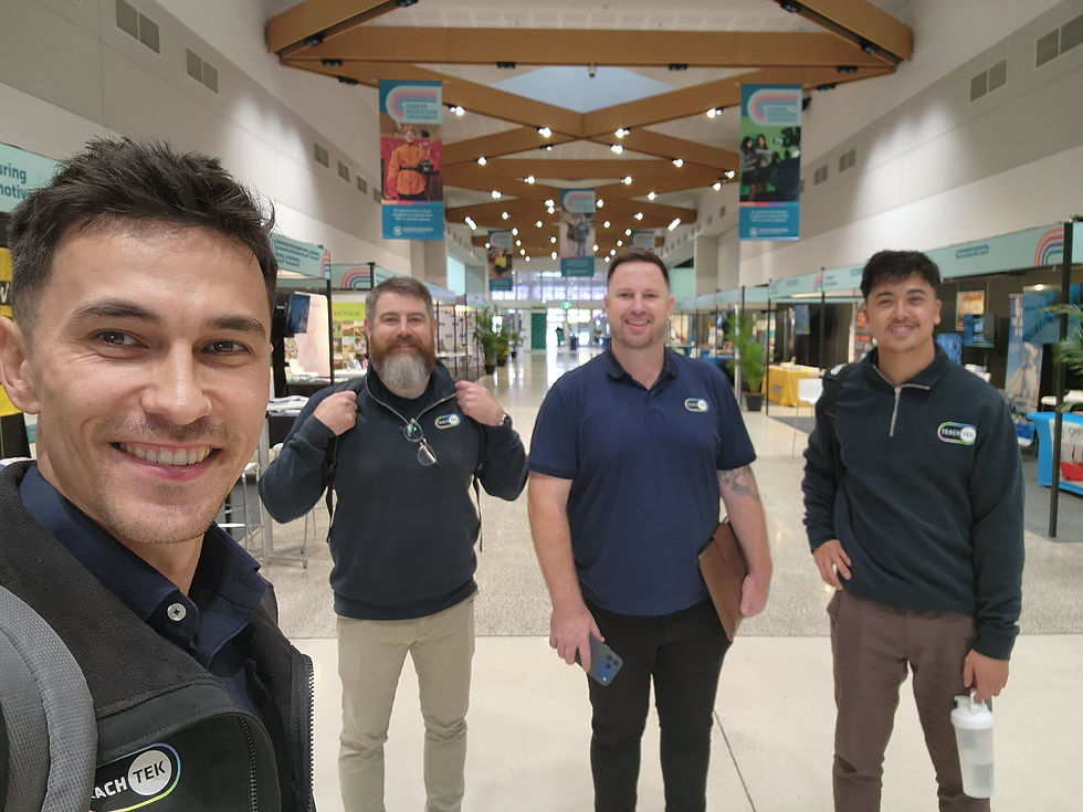 The RealityTEK team standing in an indoor center hallway.