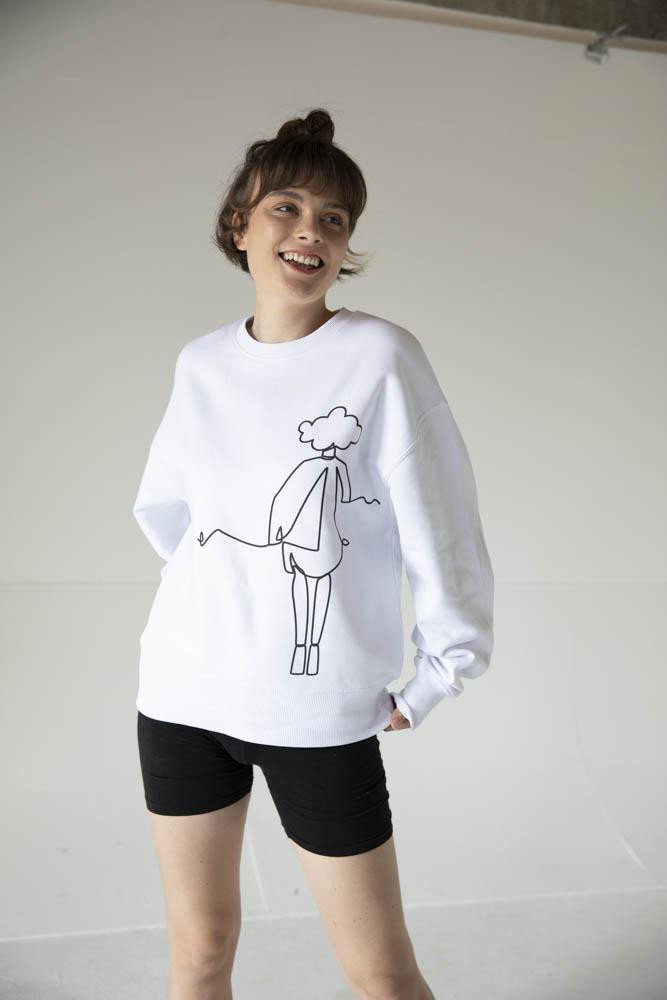White woman model wearing white jumper with black shorts.