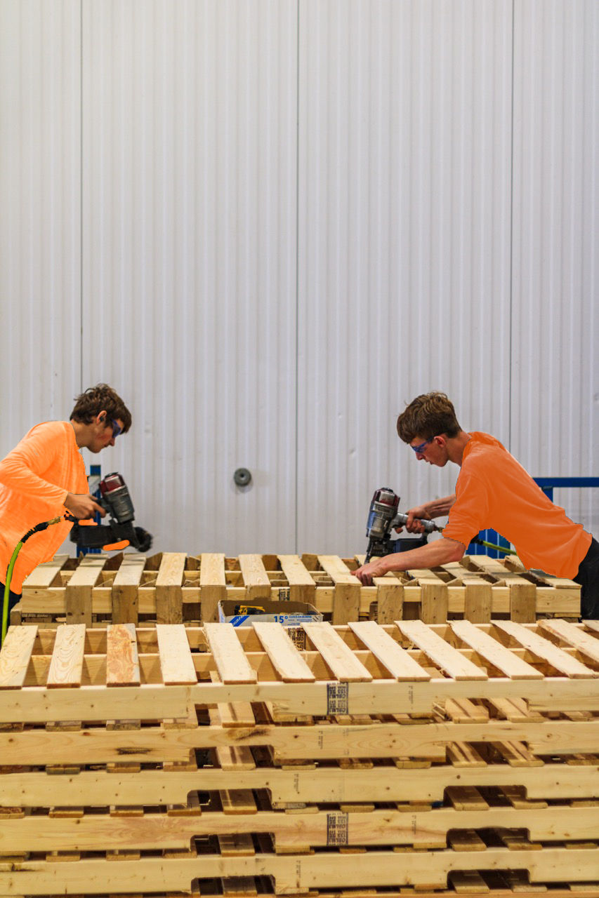 employees building custom pallet for a customer