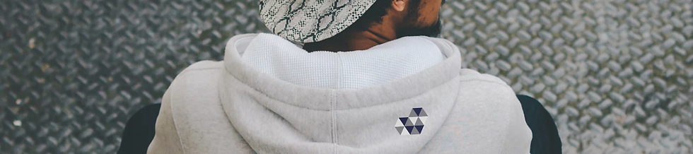 Man in hoodie sat down looking away.png