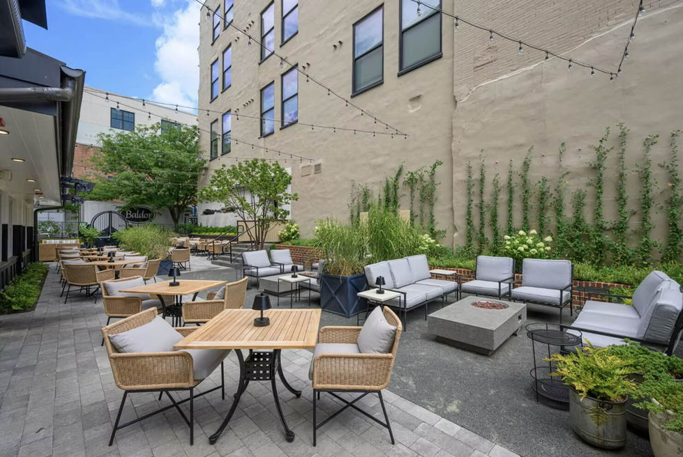outdoor restaurant dining area with cozy wooden tables and larger lounge area seating