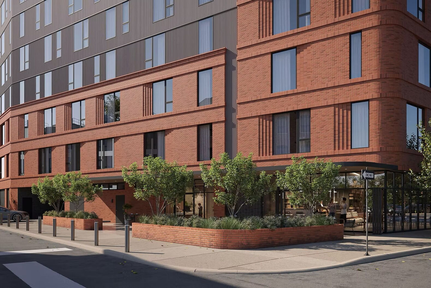 an urban street corner with plantings and small trees in brick planting beds to match the brick building