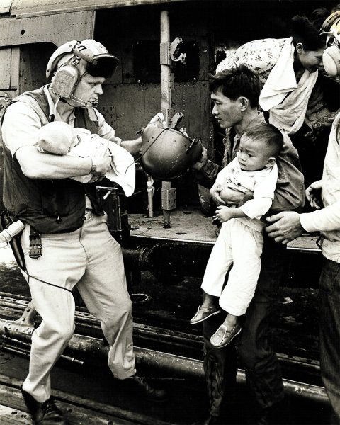 .Refugiados vietnamitas de Saigon desembarcam em navio norte-americano