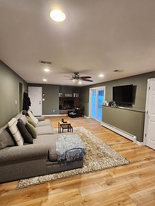 Renovated living room with gray sectional and green walls