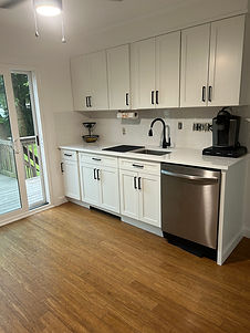 Remodeled kitchen with white cabinets and wood floor