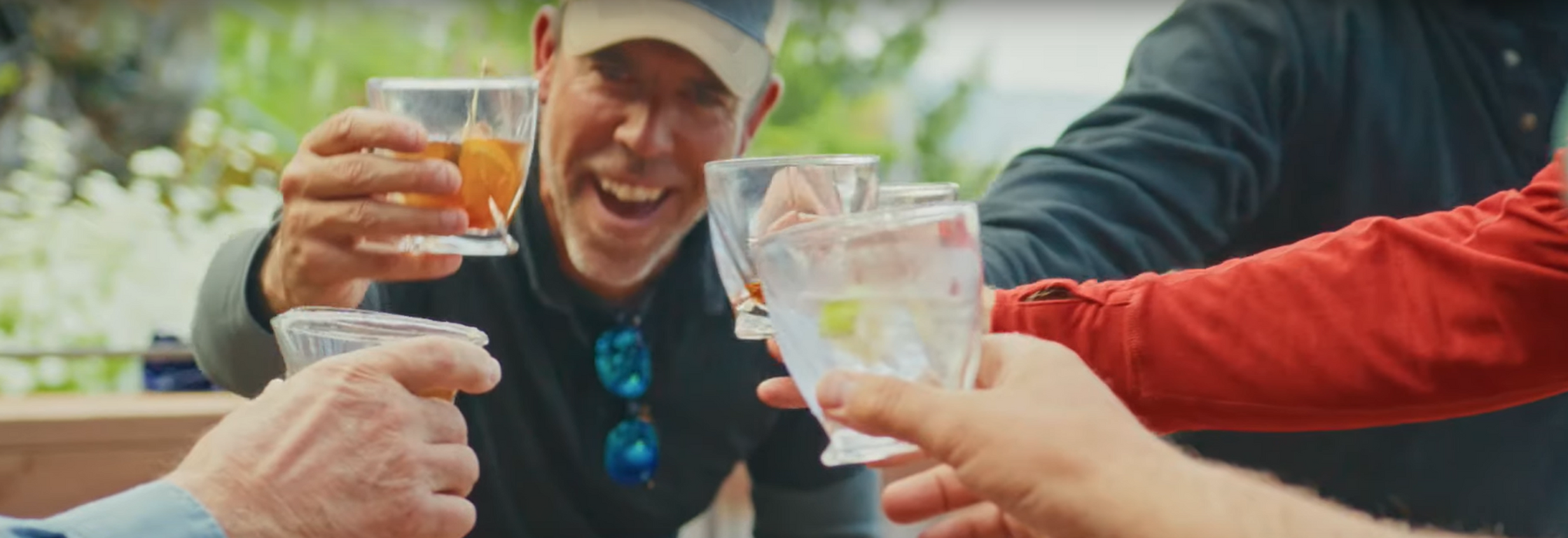 Men cheersing their drinks on the deck of Sportsman's Cove Lodge.