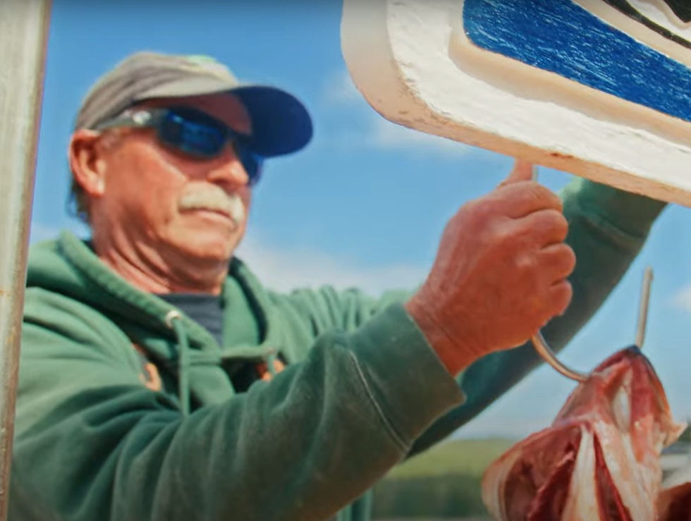 Captain Donnie at Sportsman's Cove Lodge, fixing a sign with fish hooked to the bottom