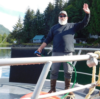 captain steve standing on the bow on a sunny day in alaska