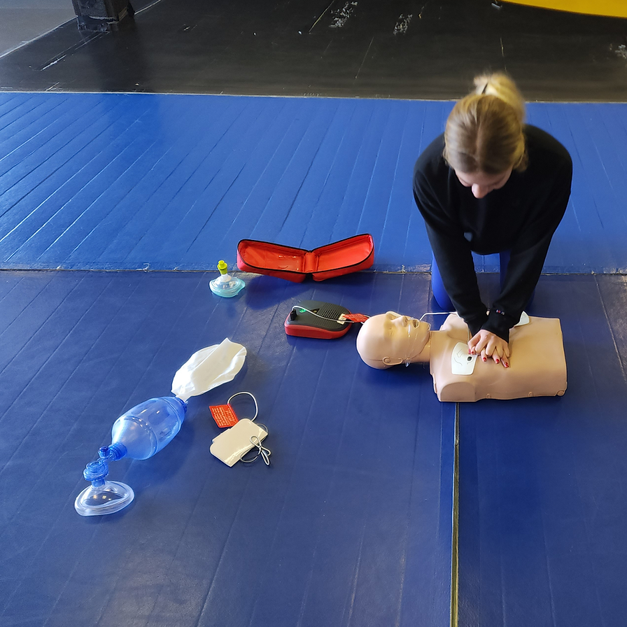 Woman practicing CPR on a medical mannequin training kit.