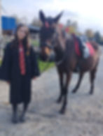 Mädchen in Hogwarts-Robe mit gesatteltem Pferd bei Veranstaltung