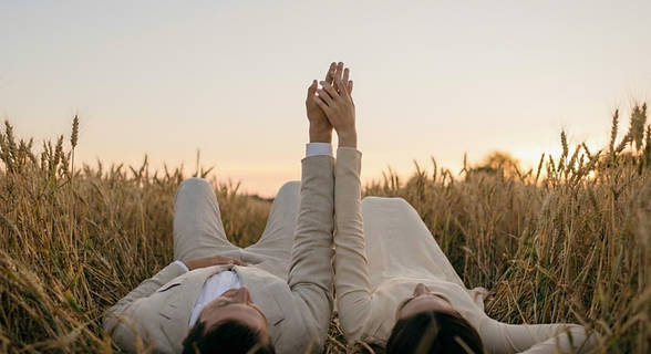 Couple qui se tiennent la main de manière romantique pendant coucher de soleil
