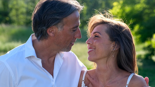 Photo artistique d'un couple qui se tient la main dans un parc au couché du soleil en été